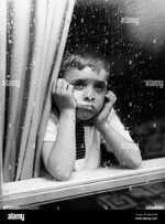 1950s-sad-boy-looking-outside-through-rainy-window-AAM3EW.jpg